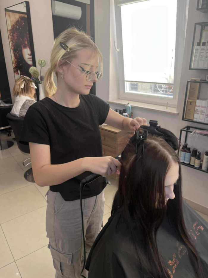 Praktykanta ćwiczy posługiwanie się lokówką