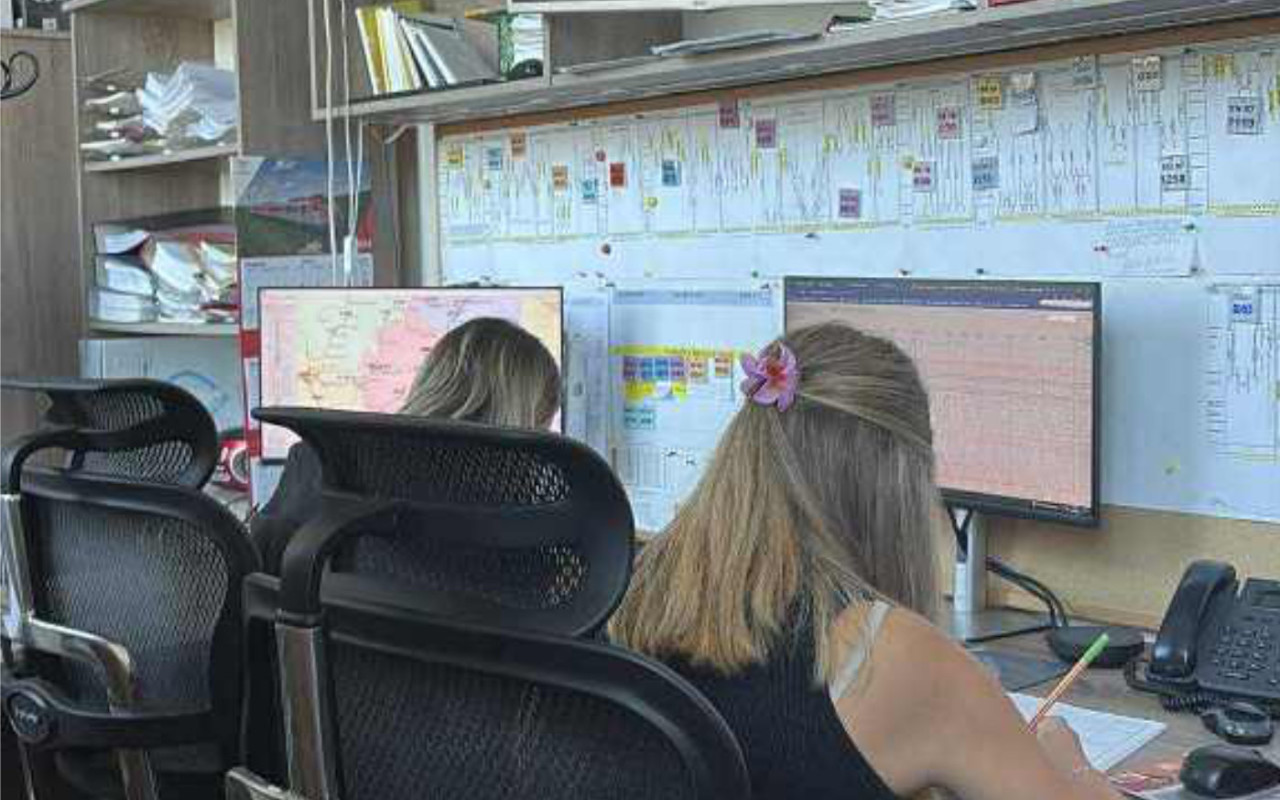 Uczennice siedzą przy biurkach i pracują na komputerach