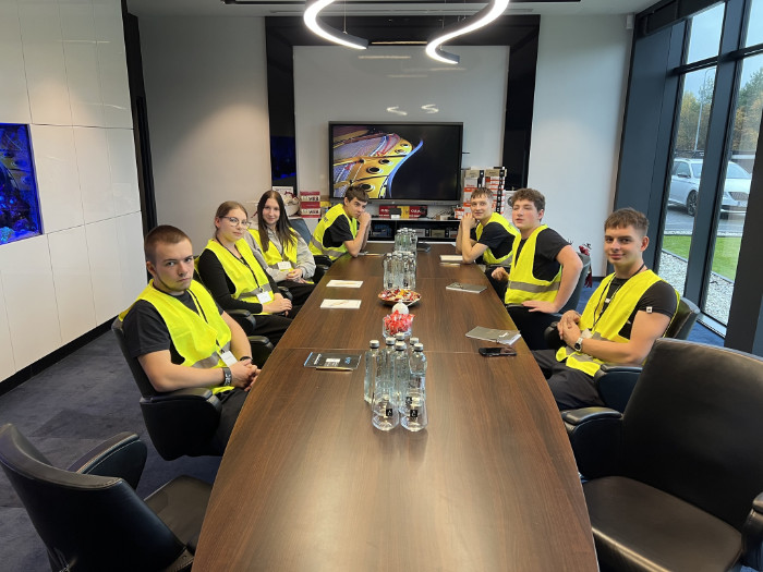 Praktykanci siedzą w sali konferncyjnej firmy