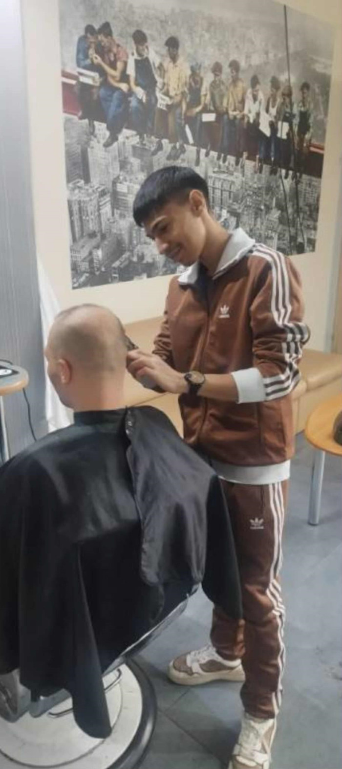 Praktykant przycina włosy klienta salonu fryzjerskiego