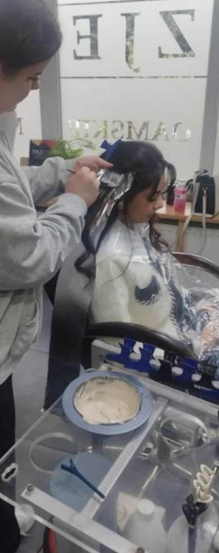 Praktykanta nakłada farbę na włosy