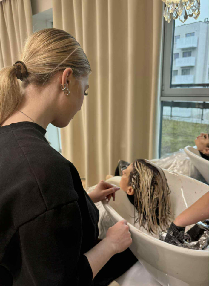 Uczennica pomaga przy nakładaniu farby na włosy