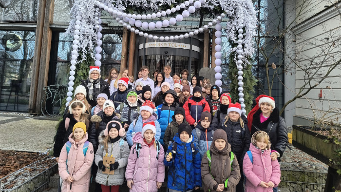 Dzieci i opiekunowie przed wejściem do Hotelu Bristol