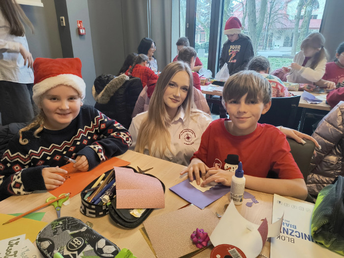 Dwoje dzieci i opiekunka podczas tworzenia kartek