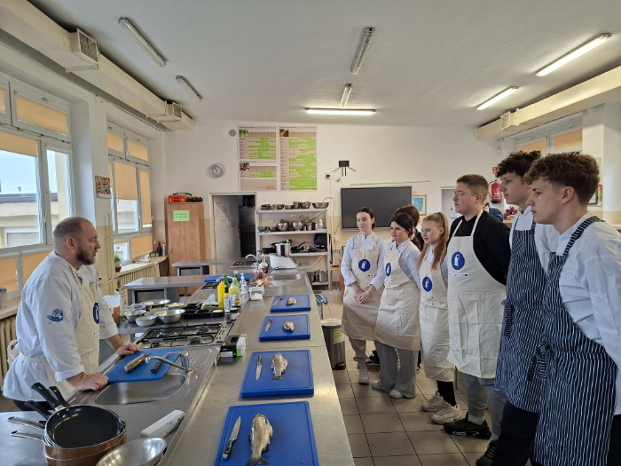 Praktykanci słuchają wskazówek prowadzącego szkolenie